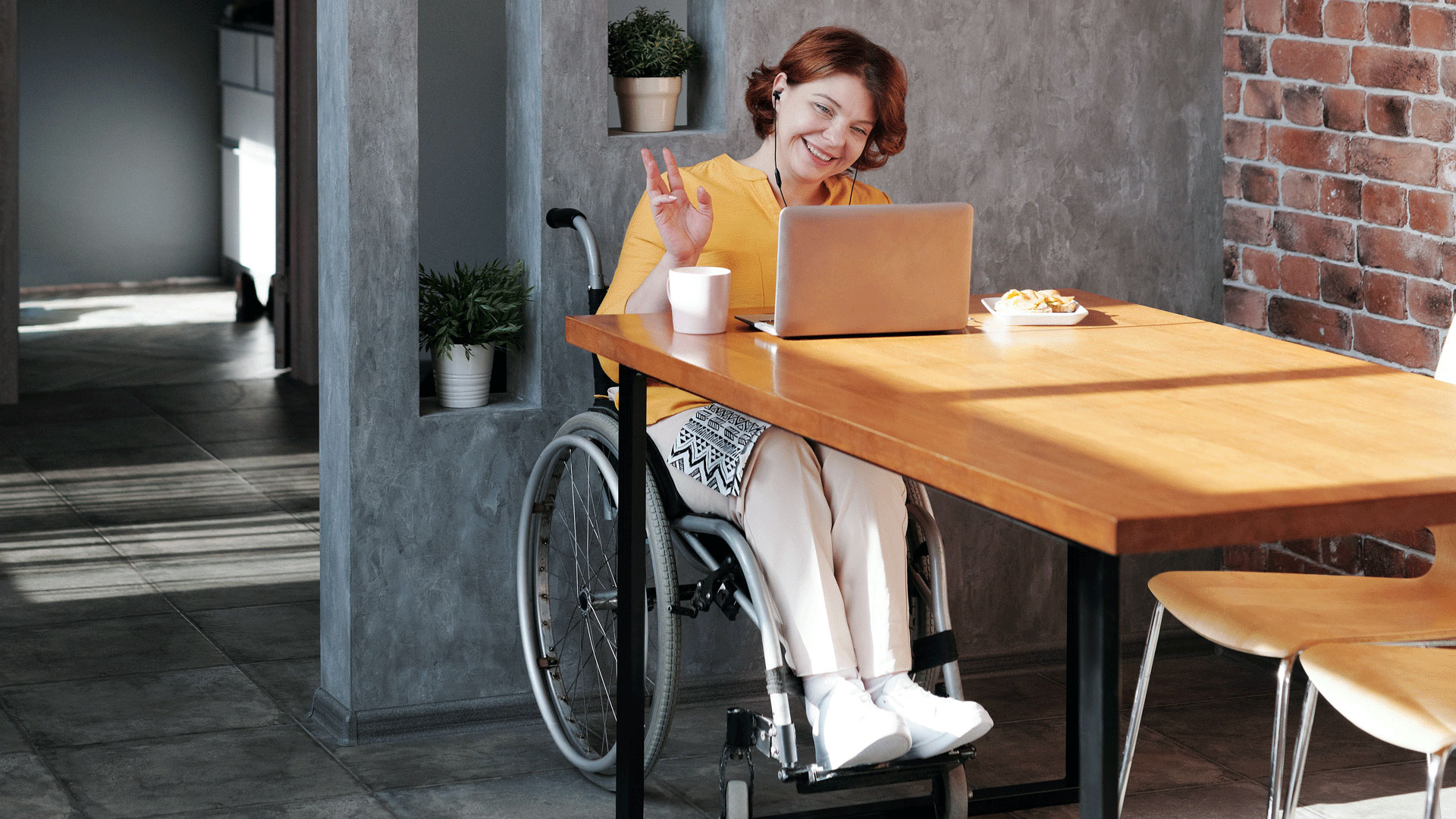 Young woman in wheelchair working on laptop Young woman in wheelchair working on laptop