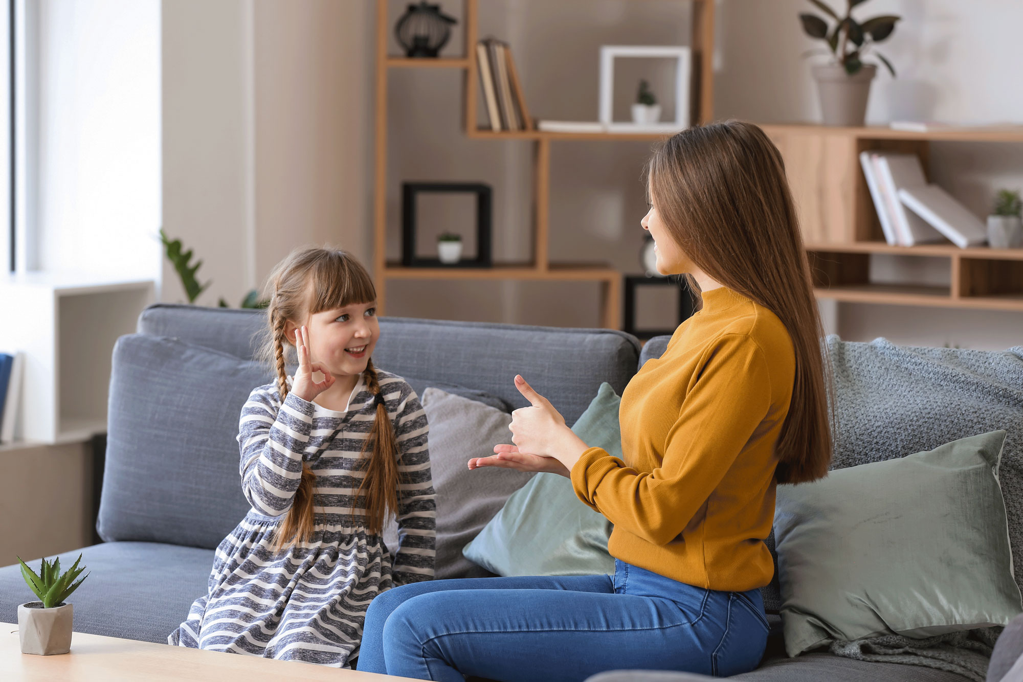Little girl with younger woman practicing sign language Little girl with younger woman practicing sign language